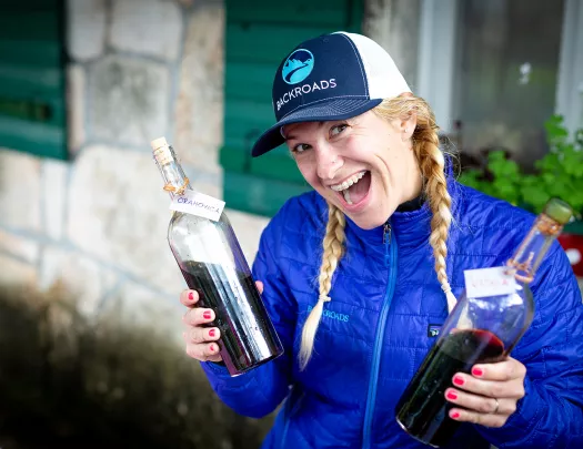 Leader with wine bottles, smiling at camera.
