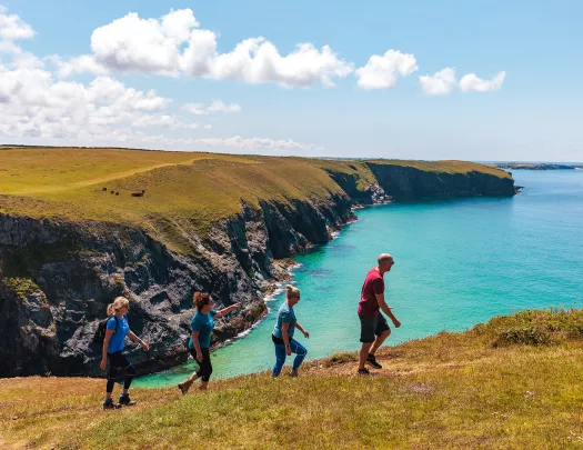 Four hikers walking up a hill in Cornwall, England