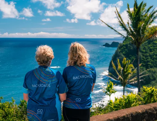Two women wearing Backroads jerseys, looking out to the ocean